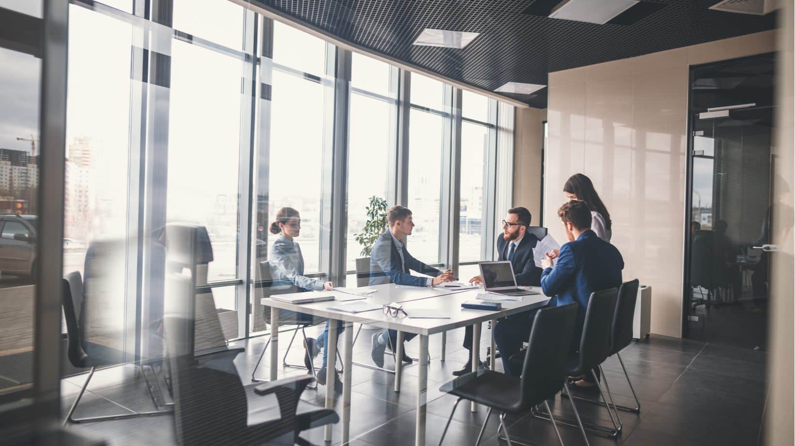 A Team Discussing Marketing Services Around A Table.