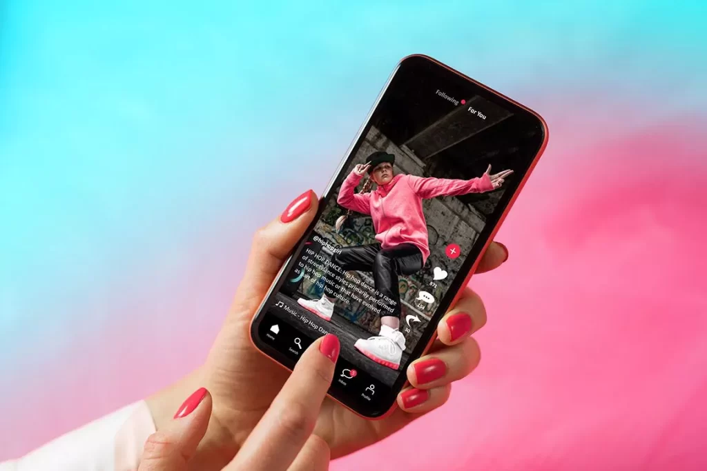 A woman creating a TikTok video of herself with her cell phone for advertising purposes.