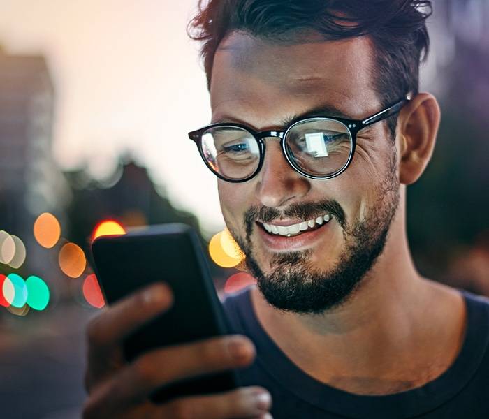 A Man Browsing On His Smartphone For Social Media Marketing Tactics.