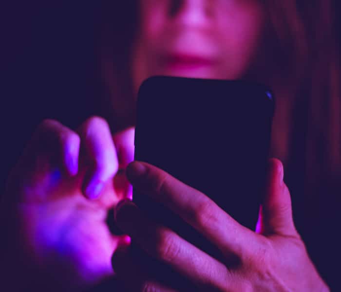 A Woman Using Paid Media With Her Phone In Hand.